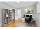 Bright office featuring hardwood floors, shelving, desk, and chair; perfect for working from home at 26752 Vosler St, Conifer, CO 80433