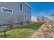 Lush backyard with green grass, xeriscape groundcover, flower bed borders, and detached garage at 12881 Park Creek Way, Firestone, CO 80504