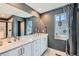 Bathroom featuring double sinks, a large mirror, and luxurious finishes with modern fixtures at 12881 Park Creek Way, Firestone, CO 80504
