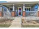 Inviting front porch with brick accents, a white railing, and space to relax and enjoy the outdoors at 12881 Park Creek Way, Firestone, CO 80504