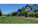 Well-maintained front yard with lawn and garden, with a view of the blue colored house at 1362 Golden Eagle Way, Louisville, CO 80027