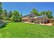 Spacious backyard featuring a well-maintained lawn, patio area, and mature trees at 7030 S Fillmore Ct, Centennial, CO 80122