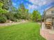 Landscaped backyard featuring a stone retaining wall, garden beds, and a lush lawn, creating a serene outdoor space at 7030 S Fillmore Ct, Centennial, CO 80122