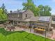 Expansive backyard featuring a spacious patio, pergola-covered bar, lush lawn, and mature trees, perfect for outdoor living at 7030 S Fillmore Ct, Centennial, CO 80122
