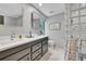 Bathroom with double vanity, a shower with glass blocks, and light tile floors at 7030 S Fillmore Ct, Centennial, CO 80122