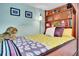 A quaint bedroom is fitted with built-in shelving around the bed and whimsical decorations at 7030 S Fillmore Ct, Centennial, CO 80122