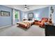 A cozy bedroom with blue walls features a ceiling fan and a comfortable reading chair near a window at 7030 S Fillmore Ct, Centennial, CO 80122