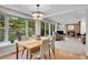 Bright dining area with a view of the garden featuring wood floors, large windows, and a brick fireplace at 7030 S Fillmore Ct, Centennial, CO 80122