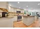 Well-lit kitchen with stainless appliances, custom cabinets, and a kitchen island at 7030 S Fillmore Ct, Centennial, CO 80122