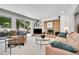 Comfortable living room featuring a brick fireplace, ample seating, and access to the outdoor space at 7030 S Fillmore Ct, Centennial, CO 80122