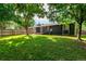 Landscaped backyard with a lush lawn, wooden fence, mature trees, and patio at 8696 W 86Th Cir, Arvada, CO 80005