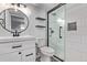 Modern bathroom featuring a sleek glass shower, floating shelves, and stylish black and white patterned tile flooring at 8696 W 86Th Cir, Arvada, CO 80005