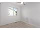 Bright bedroom features a modern ceiling fan, large window, and neutral carpet at 8696 W 86Th Cir, Arvada, CO 80005