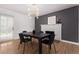 Modern dining room features a black table, contemporary light fixture, and a decorative fireplace at 8696 W 86Th Cir, Arvada, CO 80005