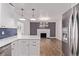 Modern kitchen with stainless steel appliances, white cabinets, quartz counters, and a blue backsplash at 8696 W 86Th Cir, Arvada, CO 80005