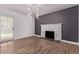 Cozy living room features a decorative fireplace, hardwood floors, and a modern light fixture at 8696 W 86Th Cir, Arvada, CO 80005