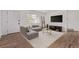 Bright living room features hardwood floors, a large sectional sofa, and a wall-mounted television at 8696 W 86Th Cir, Arvada, CO 80005