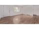 Bright living room features hardwood floors, a window, and a modern white front door at 8696 W 86Th Cir, Arvada, CO 80005