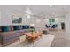Open living room area features a gray sectional, area rug, and dining space at 8696 W 86Th Cir, Arvada, CO 80005