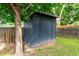 A dark-blue shed with a gray roof sitting on a green lawn at 8696 W 86Th Cir, Arvada, CO 80005