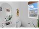 Powder room featuring a round mirror, modern sink and vanity, with a window and natural light at 6454 Leathers Ln, Parker, CO 80134