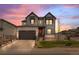 Charming two-story home with a well-manicured lawn and a spacious two-car garage at dusk at 6454 Leathers Ln, Parker, CO 80134