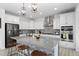 Modern kitchen featuring white cabinets, a large island with stool seating, and stainless steel appliances at 6454 Leathers Ln, Parker, CO 80134