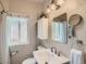 A compact bathroom featuring new lighting, and a large mirror at 1615 Osceola St, Denver, CO 80204