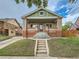 Charming brick bungalow featuring a covered porch and well-maintained front yard at 1615 Osceola St, Denver, CO 80204