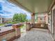 Inviting front porch with a porch swing, neutral rug, and exposed brick at 1615 Osceola St, Denver, CO 80204