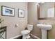 Well-lit half bathroom featuring a pedestal sink, framed mirror, and tasteful decor, convenient for guests at 26088 E Calhoun Pl, Aurora, CO 80016