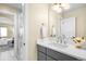 Bright bathroom featuring a gray vanity with white countertop, neutral walls, and access to an adjacent bedroom at 1688 S Grant St, Denver, CO 80210