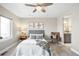 Well-lit bedroom with a ceiling fan, gray headboard, neutral walls, and a view to the bathroom at 1688 S Grant St, Denver, CO 80210