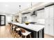 Bright kitchen features an island with bar seating, stainless steel appliances, and pendant lighting at 1688 S Grant St, Denver, CO 80210
