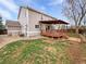Backyard featuring a wooden deck, manicured lawn, mature trees, and a well-maintained exterior at 3932 S Quatar St, Aurora, CO 80018