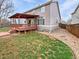 A backyard featuring a spacious wooden deck with a covered patio, perfect for outdoor entertaining and relaxation at 3932 S Quatar St, Aurora, CO 80018