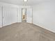 Unfurnished primary bedroom showcasing neutral paint, closet doors, and access to bathroom at 3932 S Quatar St, Aurora, CO 80018