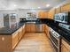 Spacious kitchen with stainless steel appliances, black countertops, and wood floors at 3932 S Quatar St, Aurora, CO 80018