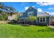 Back of house is visible from the backyard's lush lawn and patio space with seating at 1113 Southbury Pl, Highlands Ranch, CO 80129