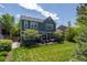 Beautiful backyard featuring a lawn, lush trees, and a cozy patio seating area at 1113 Southbury Pl, Highlands Ranch, CO 80129