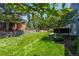 Expansive backyard with well-manicured lawn, mature trees, a stone retaining wall and an inviting patio at 1113 Southbury Pl, Highlands Ranch, CO 80129