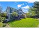 Lush backyard offers lots of space, a patio, and the rear of the home with several windows and trees at 1113 Southbury Pl, Highlands Ranch, CO 80129