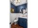 Stylish powder room featuring a blue vanity, wainscoting, and modern fixtures at 1113 Southbury Pl, Highlands Ranch, CO 80129
