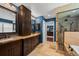 Elegant bathroom featuring double vanities, a walk-in shower, and a doorway leading to the primary bedroom at 1113 Southbury Pl, Highlands Ranch, CO 80129