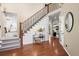 Grand entryway with hardwood floors, staircase with iron railing, and views into the kitchen and living room at 1113 Southbury Pl, Highlands Ranch, CO 80129