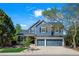 Two-story home features a well-manicured lawn, beautiful trees, an attached two-car garage, and pleasing curb appeal at 1113 Southbury Pl, Highlands Ranch, CO 80129