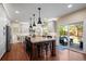 Bright kitchen featuring an island with seating, stainless steel appliances, hardwood floors, and access to the outdoor patio at 1113 Southbury Pl, Highlands Ranch, CO 80129