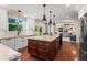 Spacious kitchen features a large center island, stainless steel appliances, and flows into the living room at 1113 Southbury Pl, Highlands Ranch, CO 80129