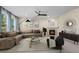 Living room with neutral tones, fireplace, ceiling fan and large window at 1113 Southbury Pl, Highlands Ranch, CO 80129
