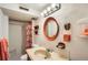 Full bathroom with vanity, patterned shower curtain, and decorative mirror at 7245 W 70Th Ave, Arvada, CO 80003